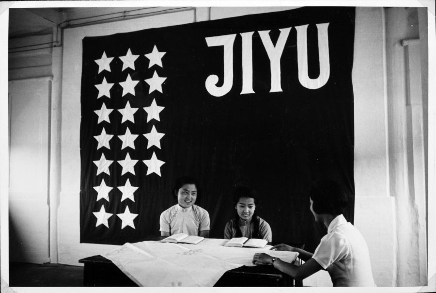 Two Chinese school students take lessons in Japanese beneath the flag of the Peking Jiyu Gakuen.