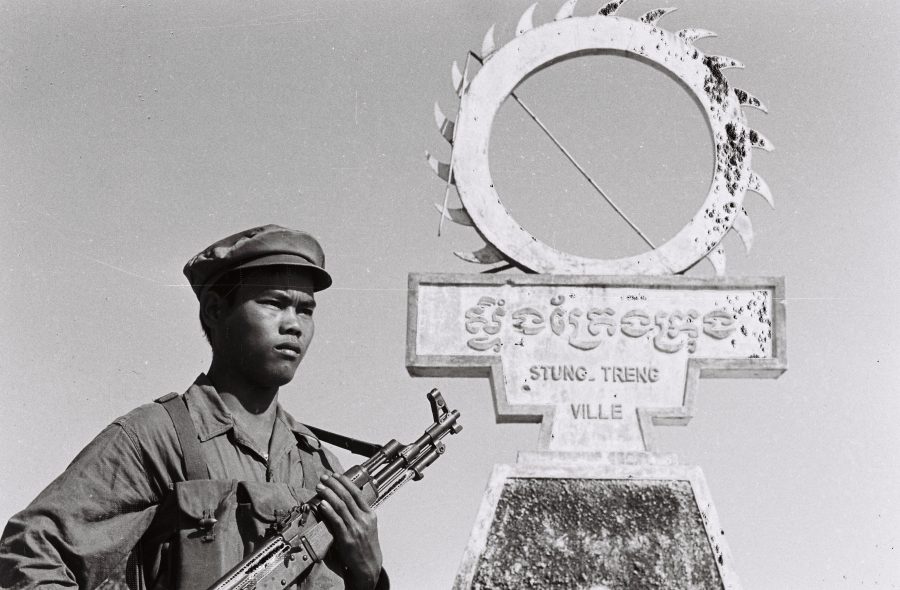 A soldier stands guard with a machine gun