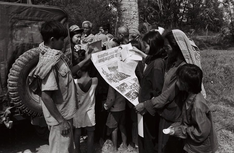 Villagers looking at a propaganda poster