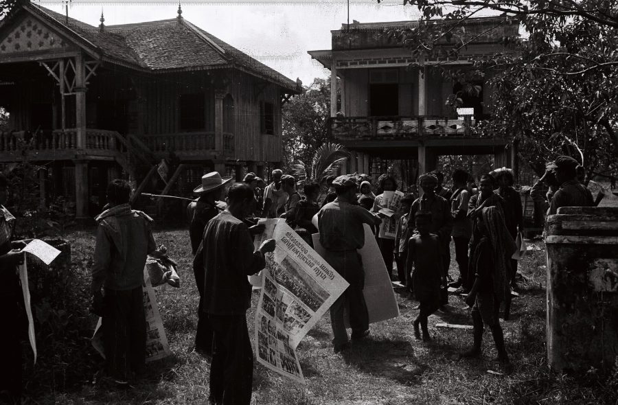 Soldiers giving out posters to villagers