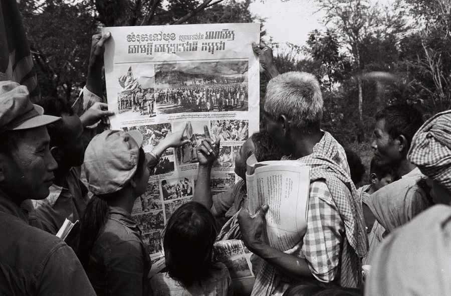 A group of people pointing at a poster