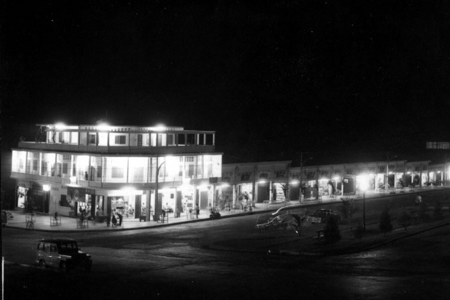 Night scene of shops and traffic on street corner